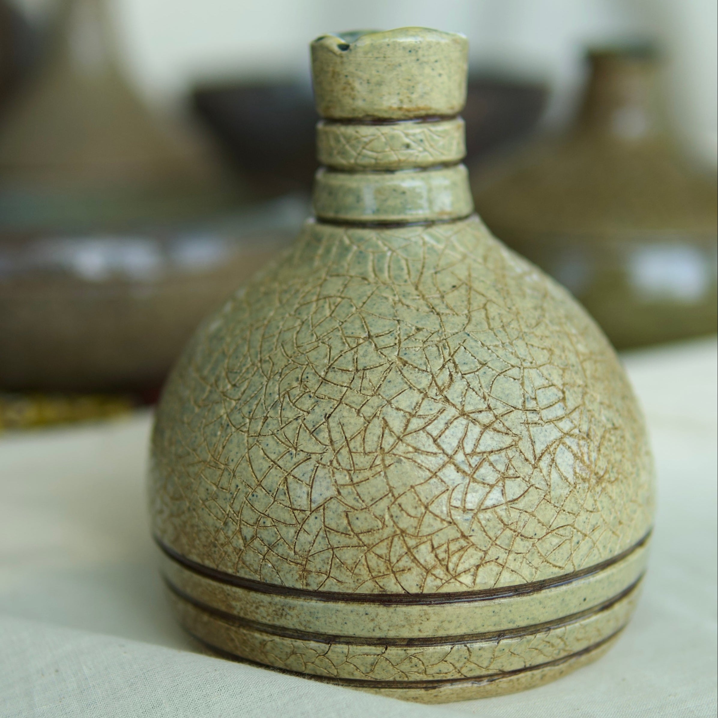 light colored ceramic vessel with with crackled texture