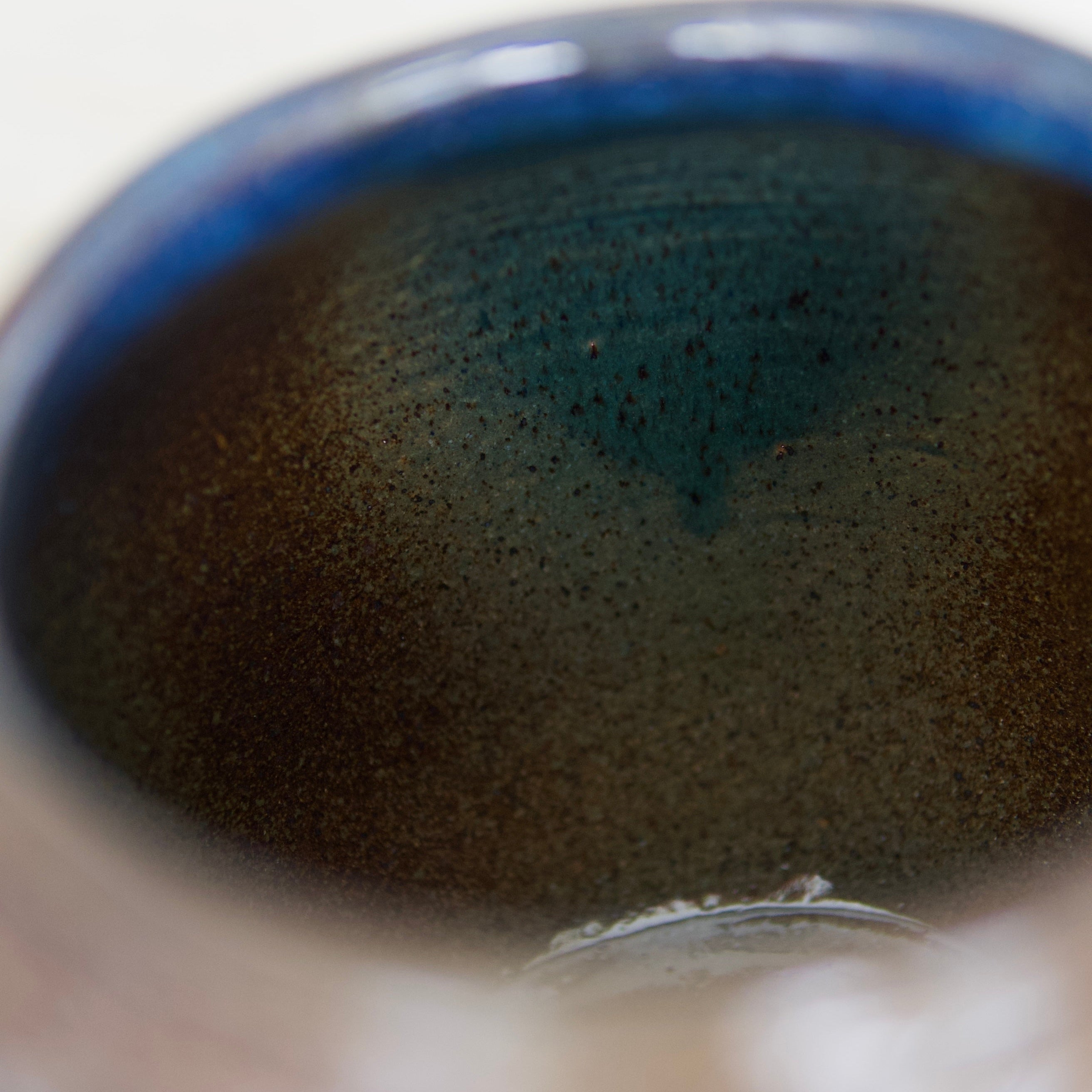 Blue, light green, and brown ombre glaze inside a ceramic vessel